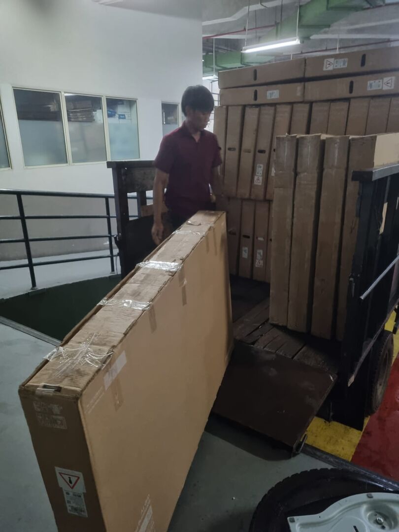 Unit TV layar besar dalam dus disiapkan dengan troli untuk pesanan jual beli partai besar