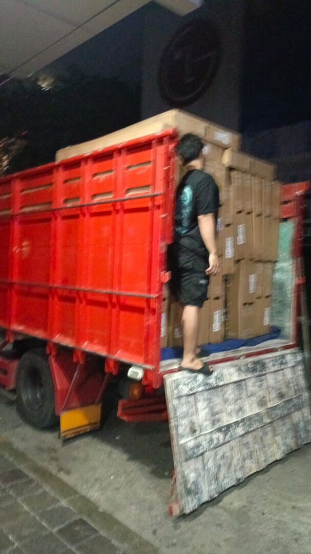 Truk dimuat penuh dus TV untuk pengiriman pesanan partai besar pada malam hari